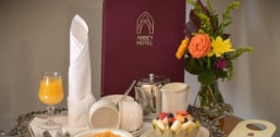 Elegant breakfast service with juice, fresh fruit, and flowers.
