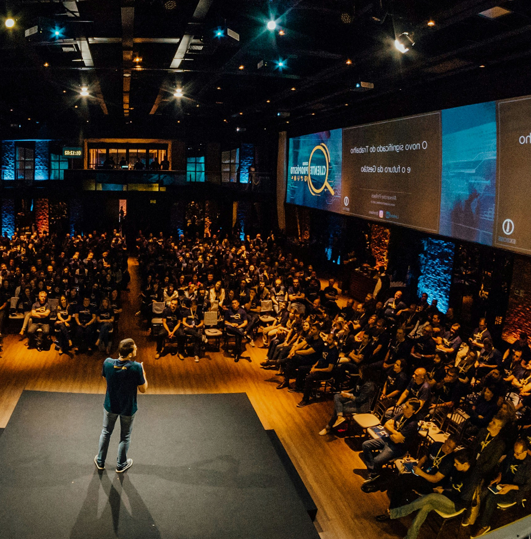 A speaker on stage addressing a large audience