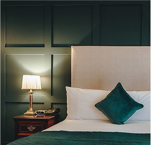 bed with a bedside table with a lamp on it