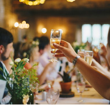 A festive table setting with a woman's hand holding a wine glass