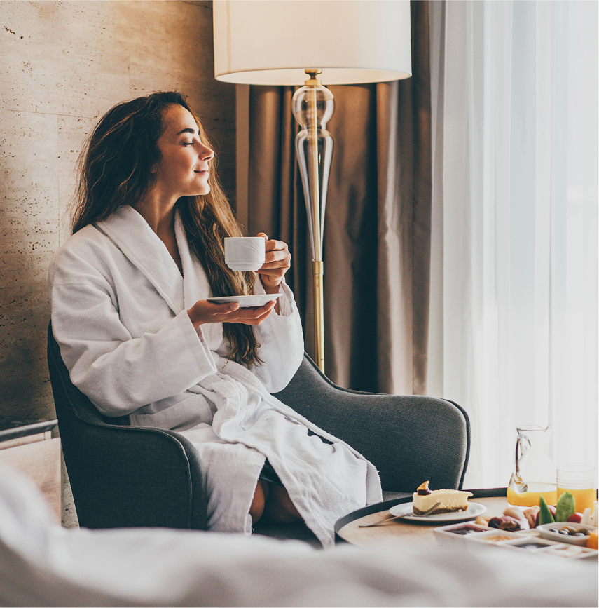 Girl drinking coffee in hotel room