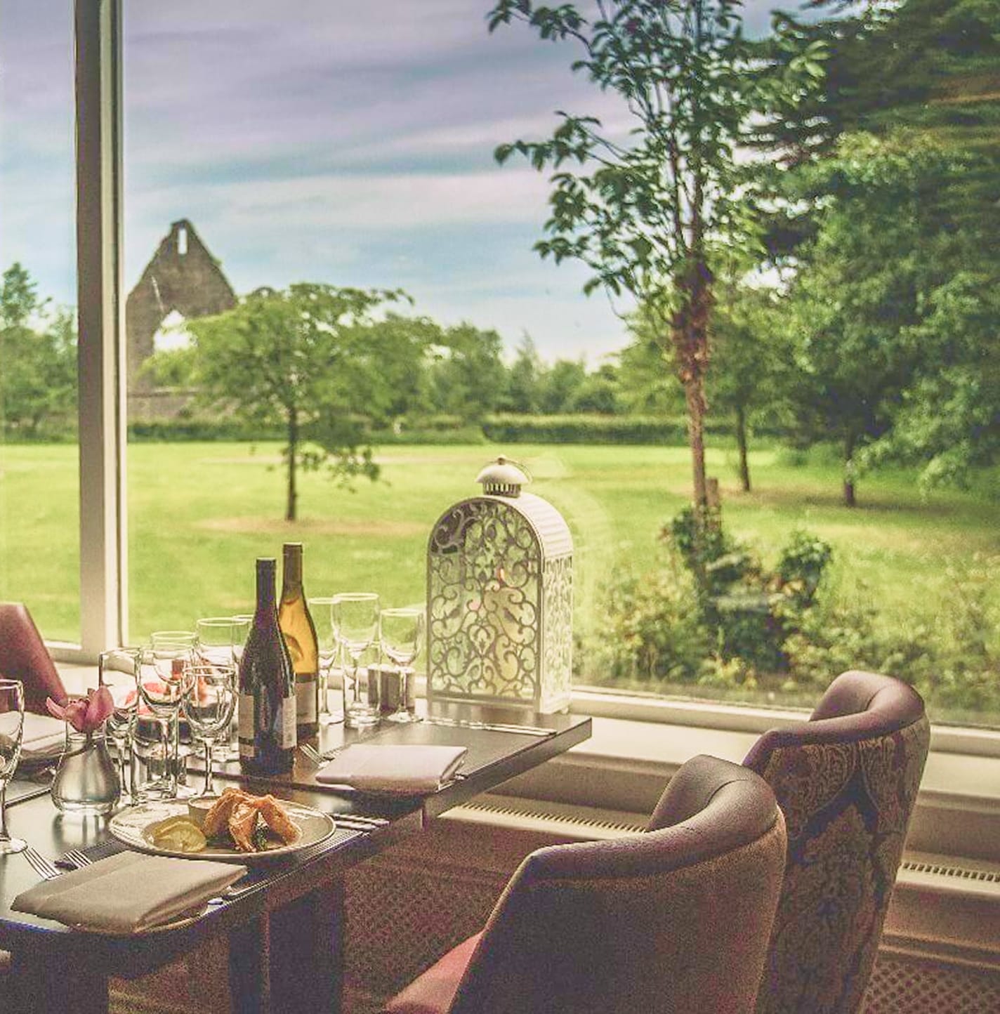 Restaurant seating overlooking luscious gardens and ruins.